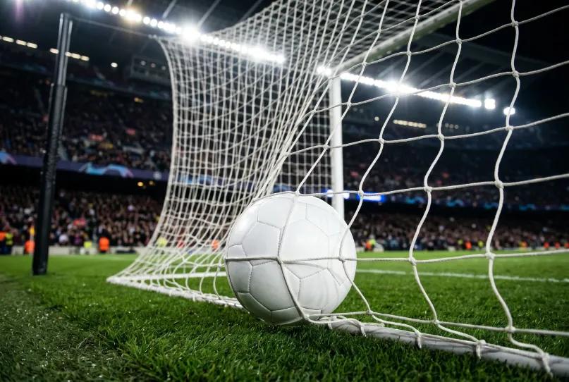 Bola de futebol junto a uma baliza com rede da Champions League